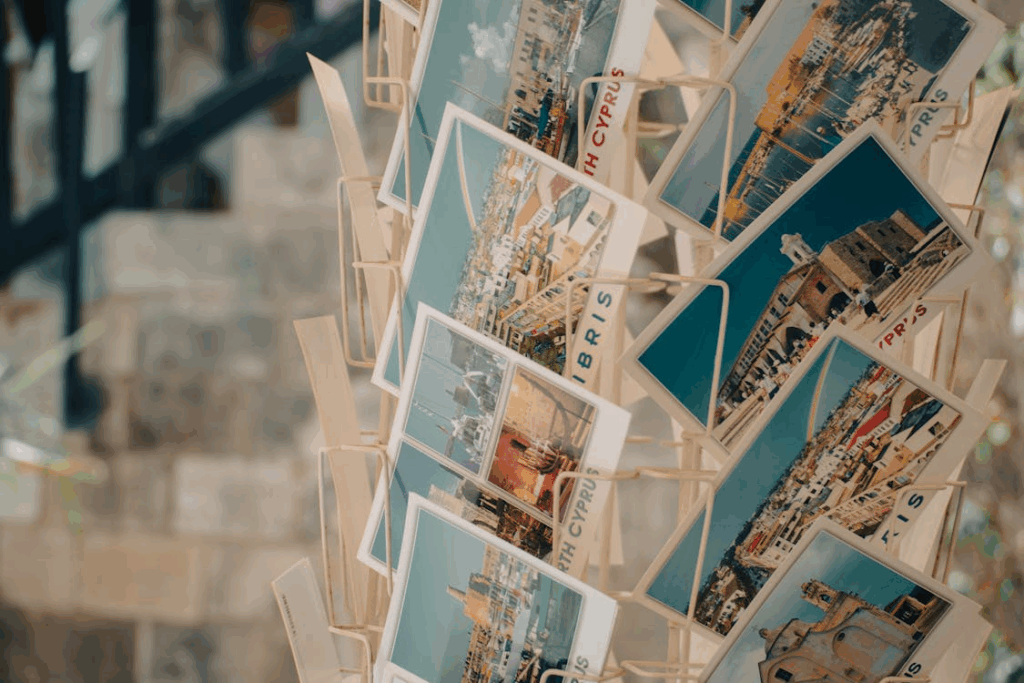 Close-up of a rotating rack of Cyprus travel postcards on a street, capturing postcard history.