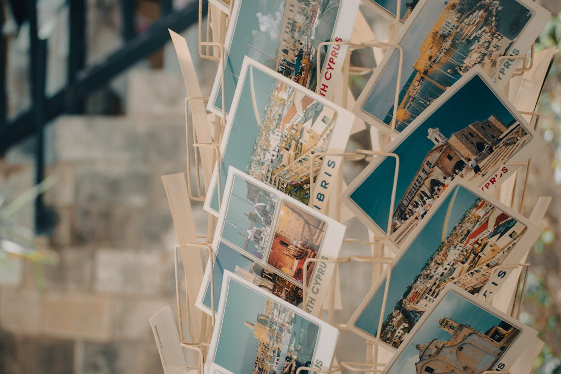Close-up of a rotating rack of Cyprus travel postcards on a street, capturing postcard history.