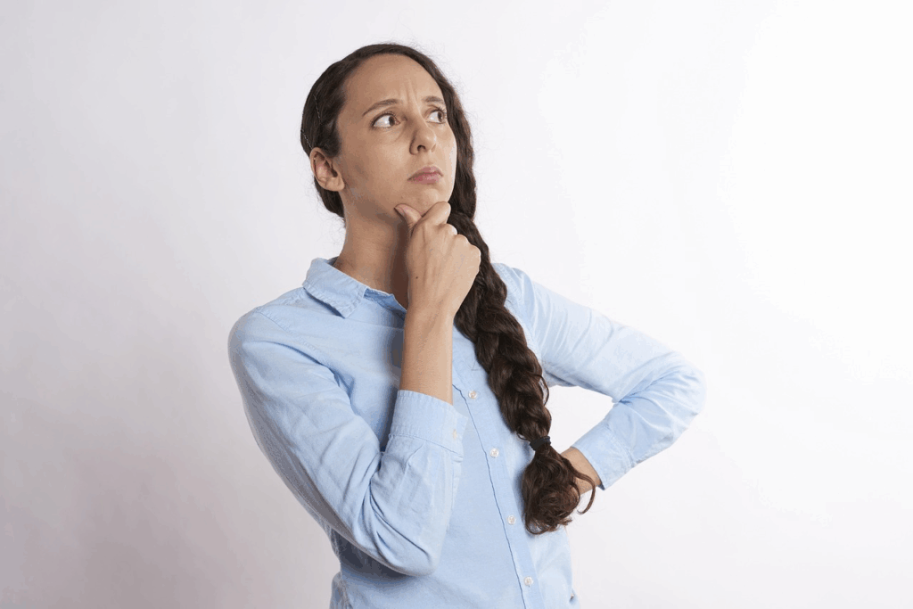 Thoughtful woman in a light blue shirt appearing confused as if experiencing déjà vu,