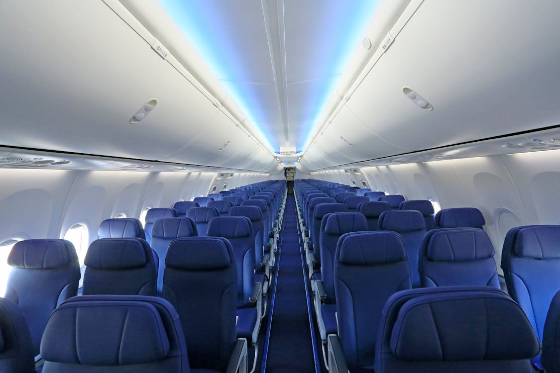 Airplane cabin interior with rows of blue seats, illustrating airplane seat color psychology.