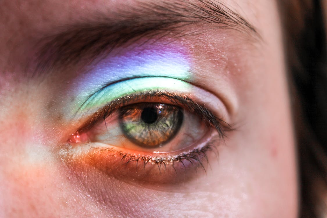 Close-up of a human eye with rainbow light, illustrating color vision and tetrachromacy.