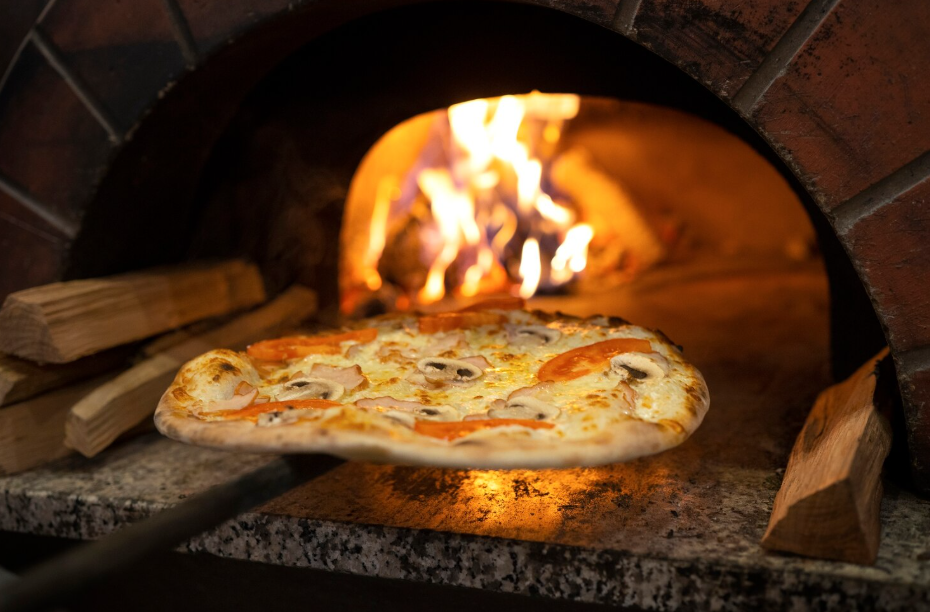 Neapolitan-style pizza sliding into a flaming brick oven.